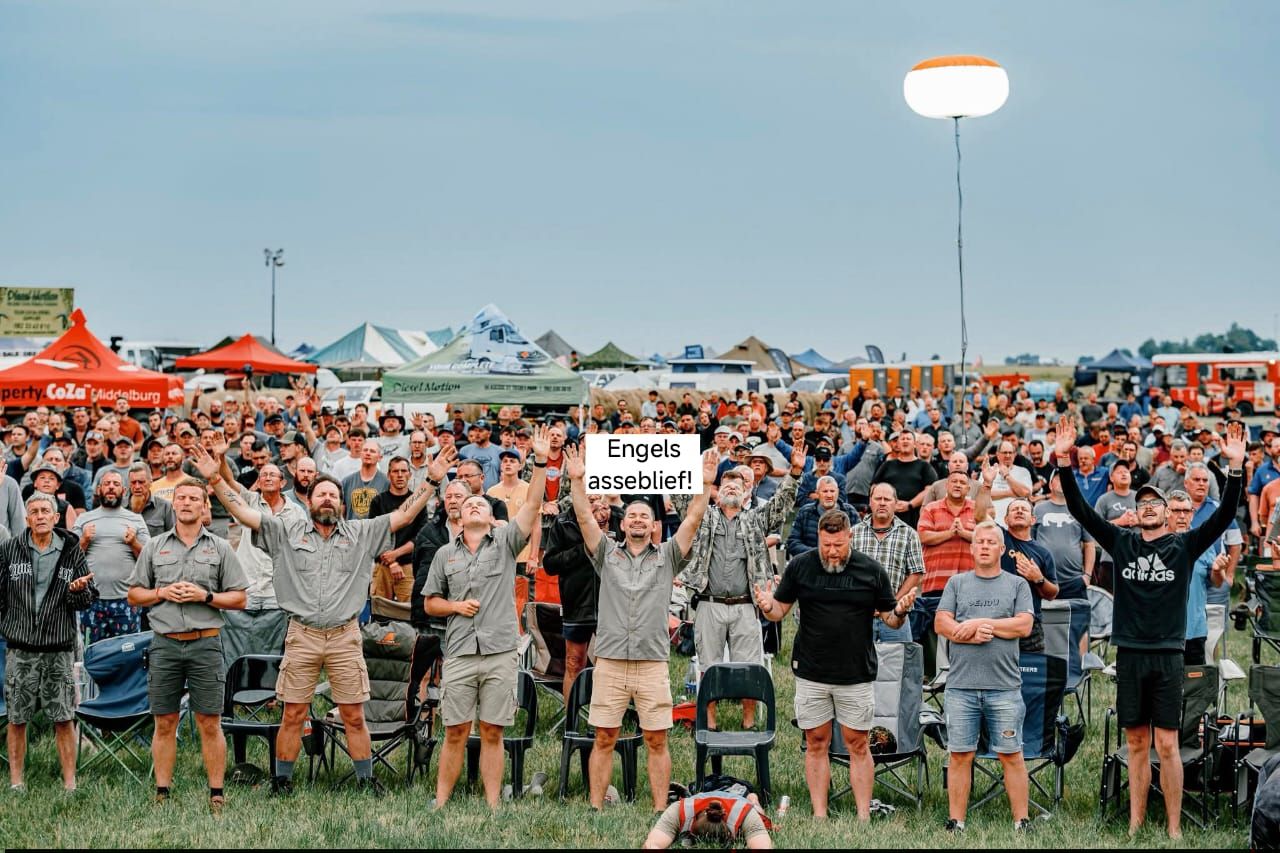 Men worshipping together in front of the camp