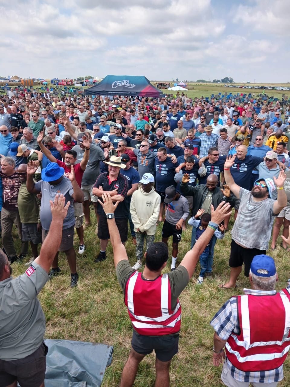 Men with arms raised during worship