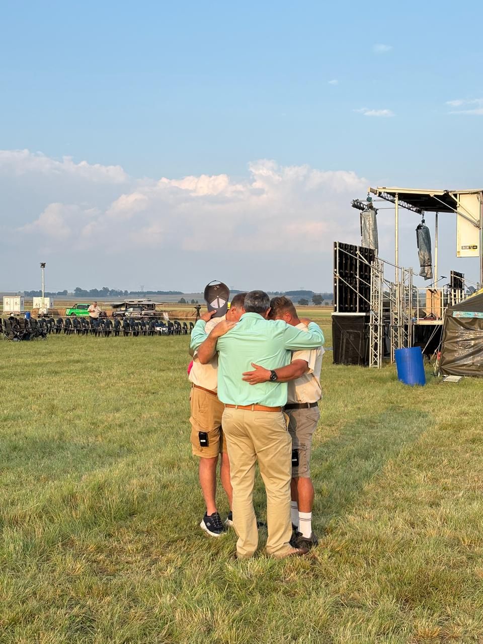 Two men embracing in front of the stage