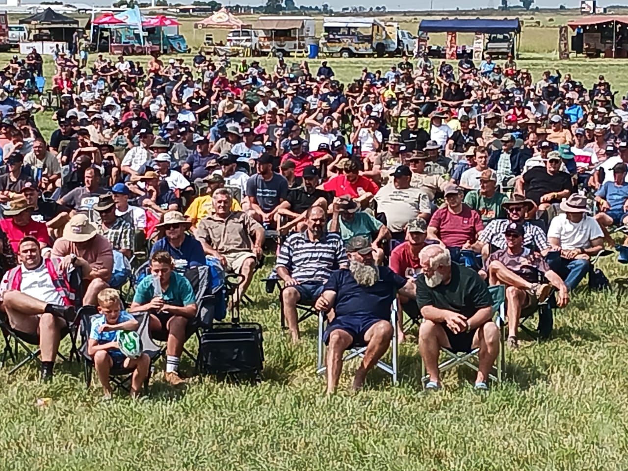 Men seated across the field during a session